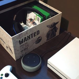caixa organizadora estampa The Mandalorian com o Baby Yoda em cima de uma mesa ao lado de um videogame e uma assistente virtual