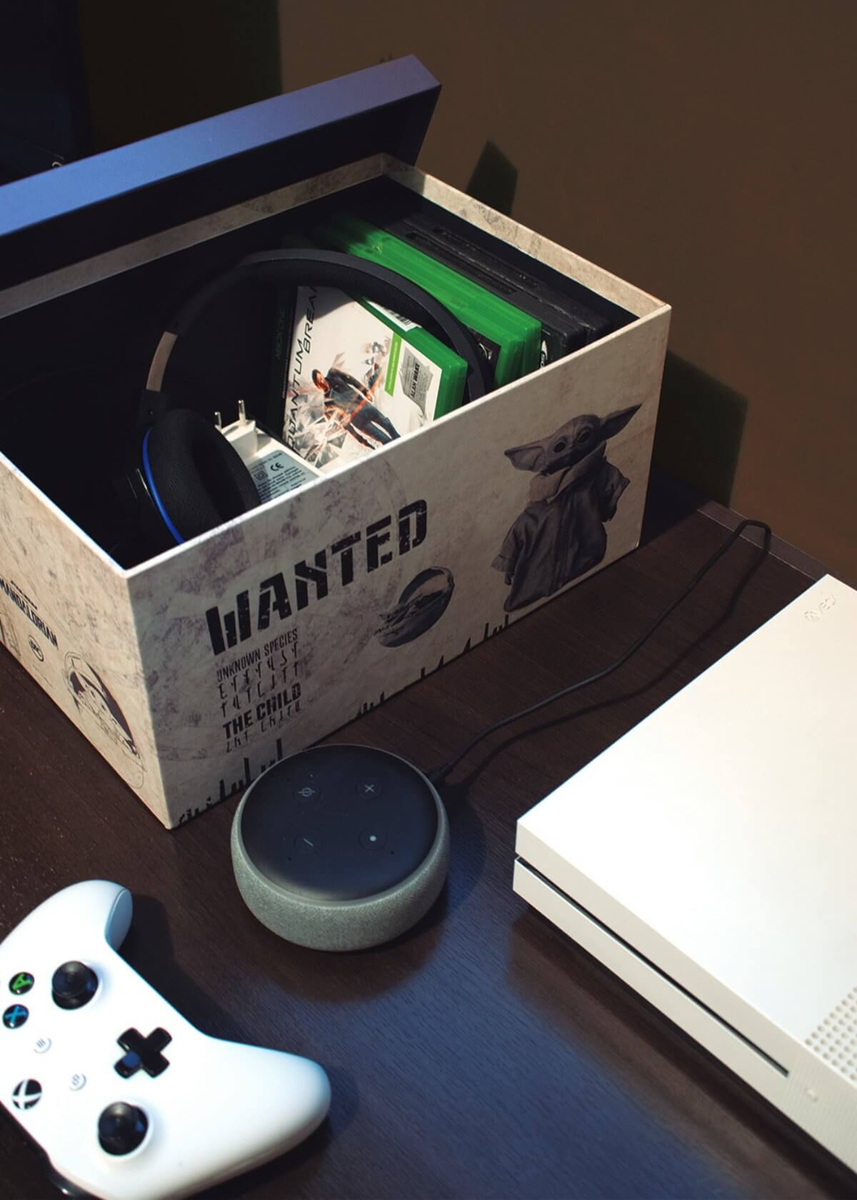 caixa organizadora estampa The Mandalorian com o Baby Yoda em cima de uma mesa ao lado de um videogame e uma assistente virtual