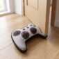 Peso de porta controle de videogame segurando porta branca aberta