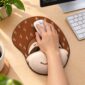 Mão utilizando o mouse pad Preguiça Face Kawaii em uma mesa, com apoio de pulso integrado.